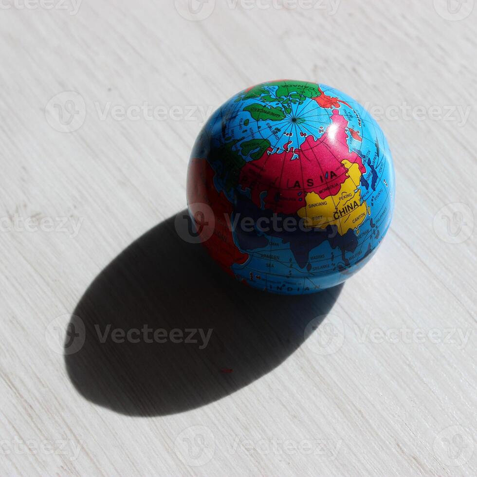 A deep shadow cast by a globe on the illuminated side, showing the countries of the Asian continent photo