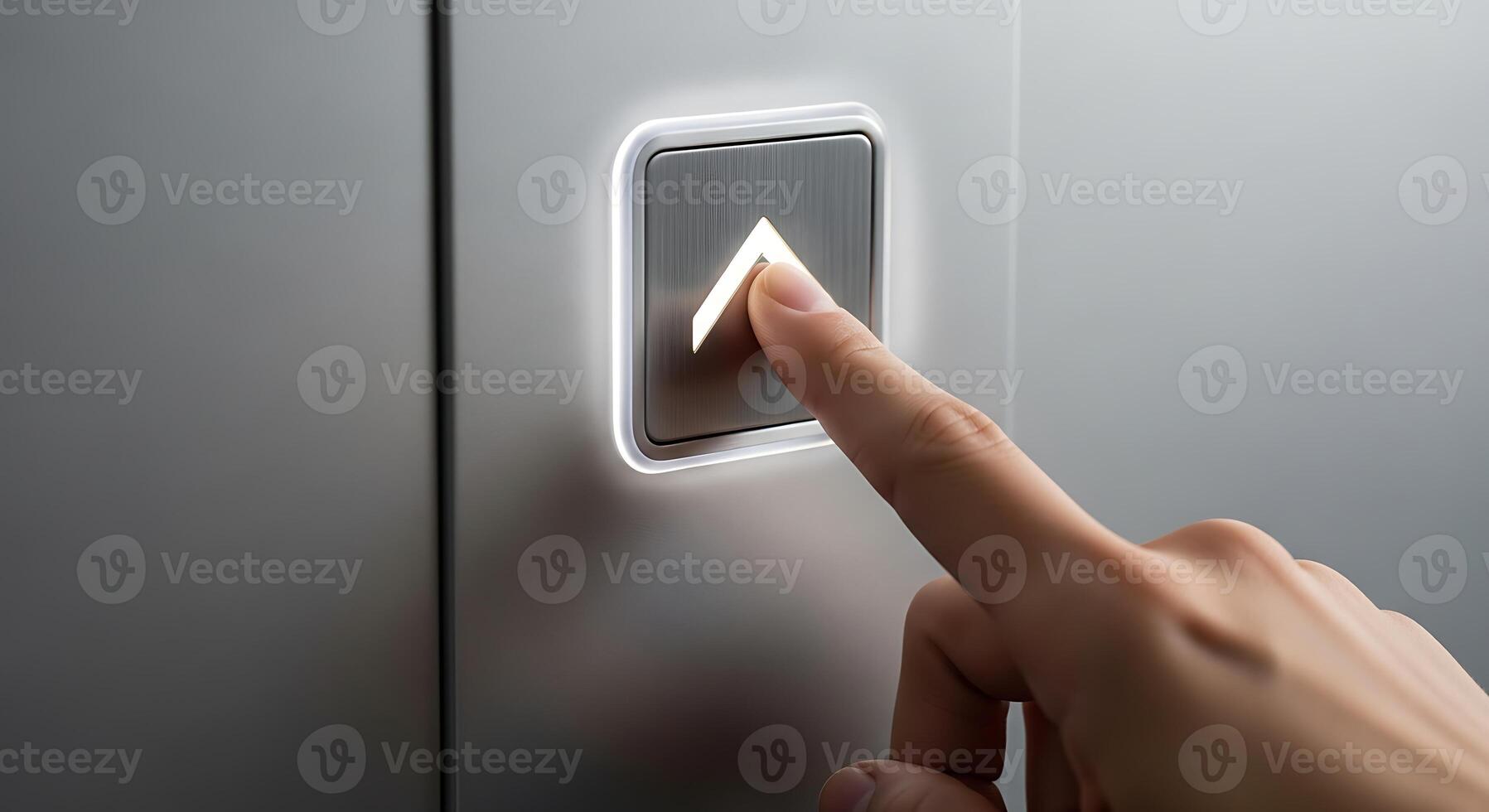 Person Pressing Elevator Button with Illuminated Arrow in Modern Metallic Setting photo