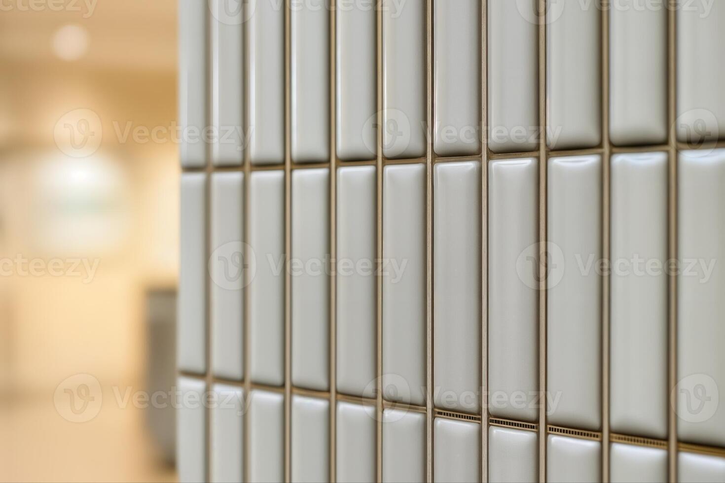 Modern Tile Wall Indoors Featuring Smooth White Rectangular Tiles Arranged Vertically With A Blurred Background Creating A Minimalist Aesthetic photo