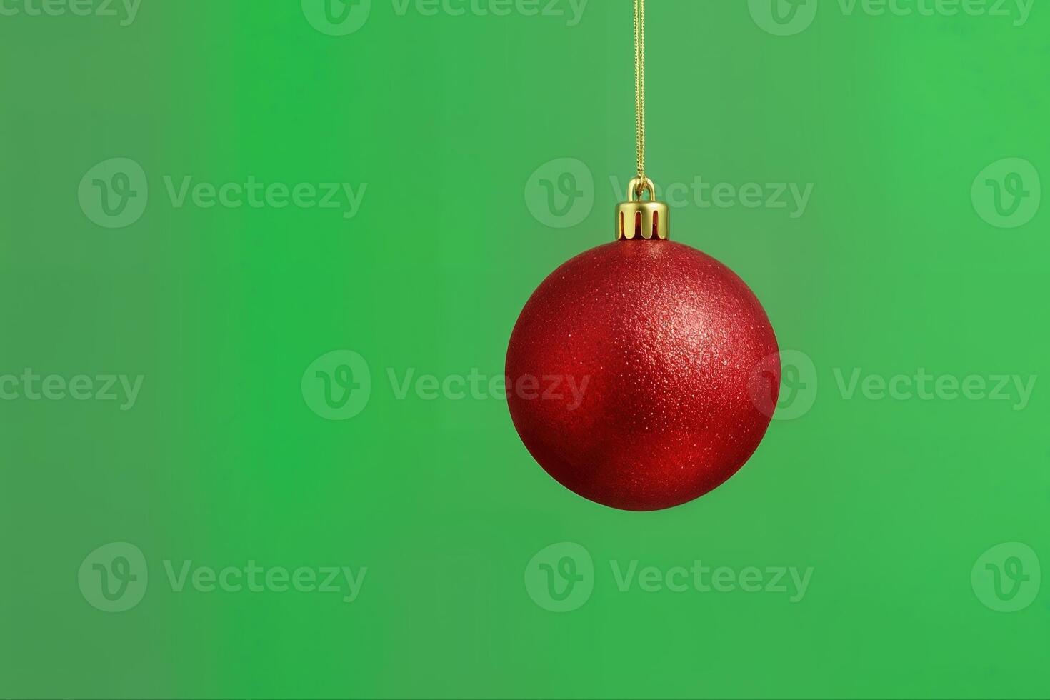 Christmas Ornament Hanging Against a Green Background Emphasizing Its Shiny Red Surface and Simple Elegant Design with a Closer Perspective photo