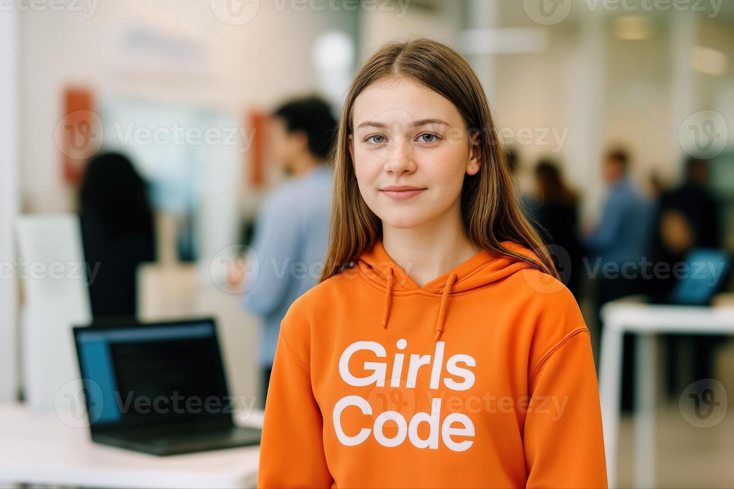 Tech Fair Featuring Girls Coding With Young Female Participant in an Indoor Setting Surrounded by Event Attendees and Laptops in a Bright Modern Venue photo