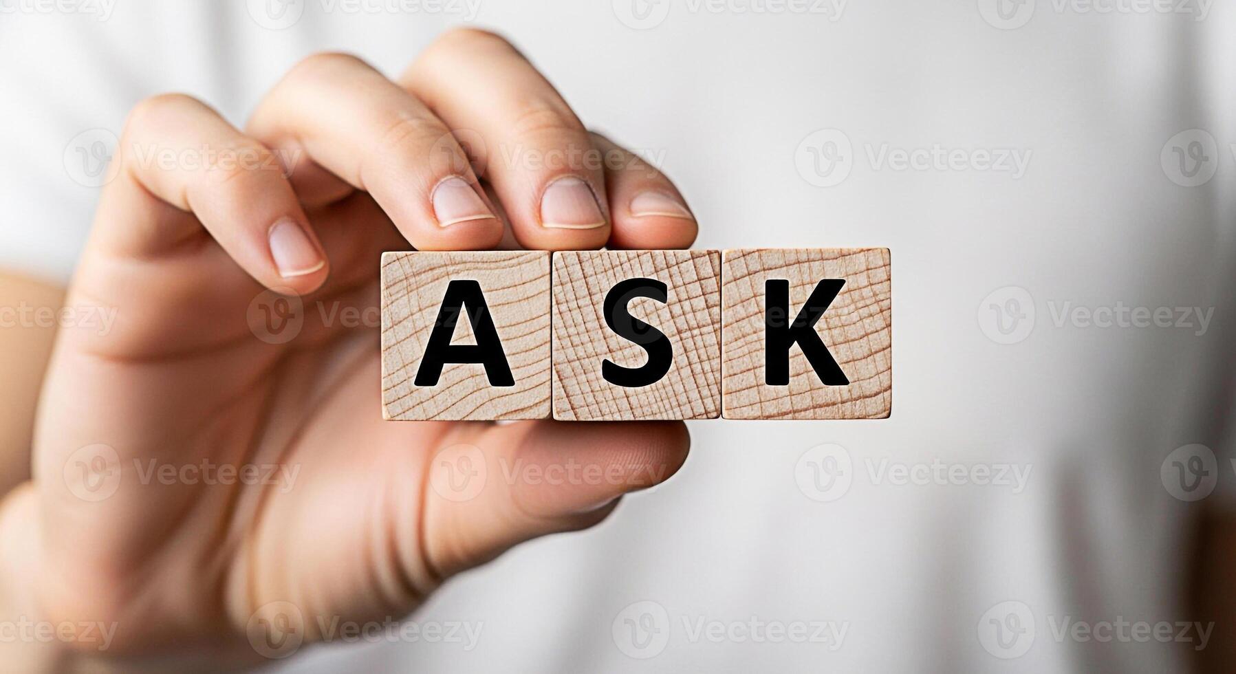 Closeup of a hand holding wooden blocks spelling ASK against a neutral background symbolizing curiosity seeking information problemsolving and the importance of questioning in learning and communicati photo