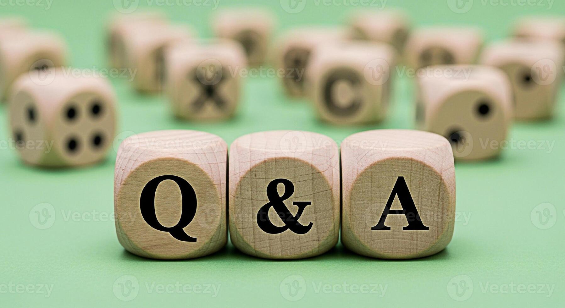Wooden dice spelling out Q A on a green surface representing questions and answers in a business or educational setting conveying a sense of clarity knowledge and problemsolving photo