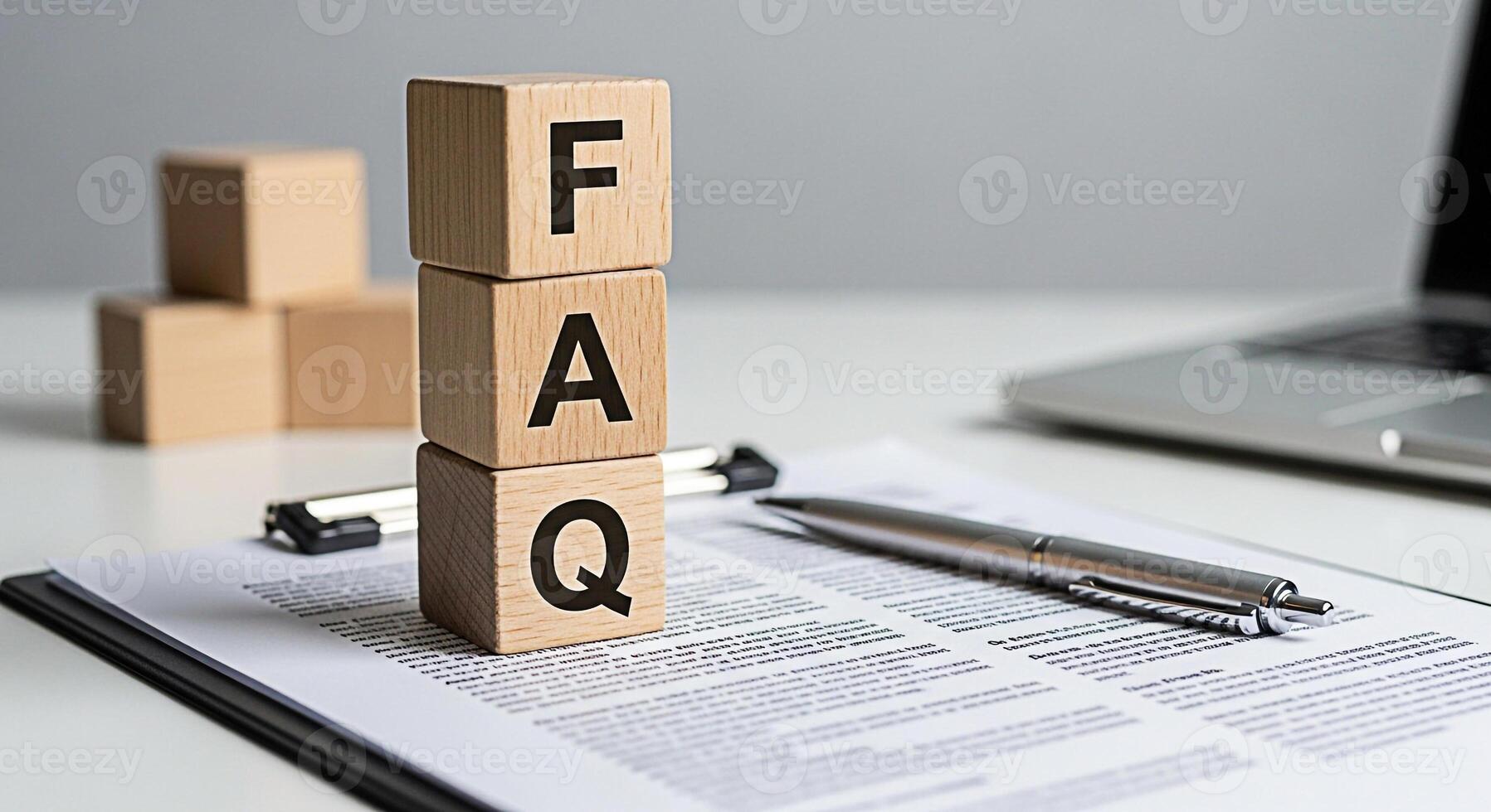Wooden FAQ blocks stacked on a document with a pen in a bright office setting representing frequently asked questions and providing answers conveying clarity and information access photo