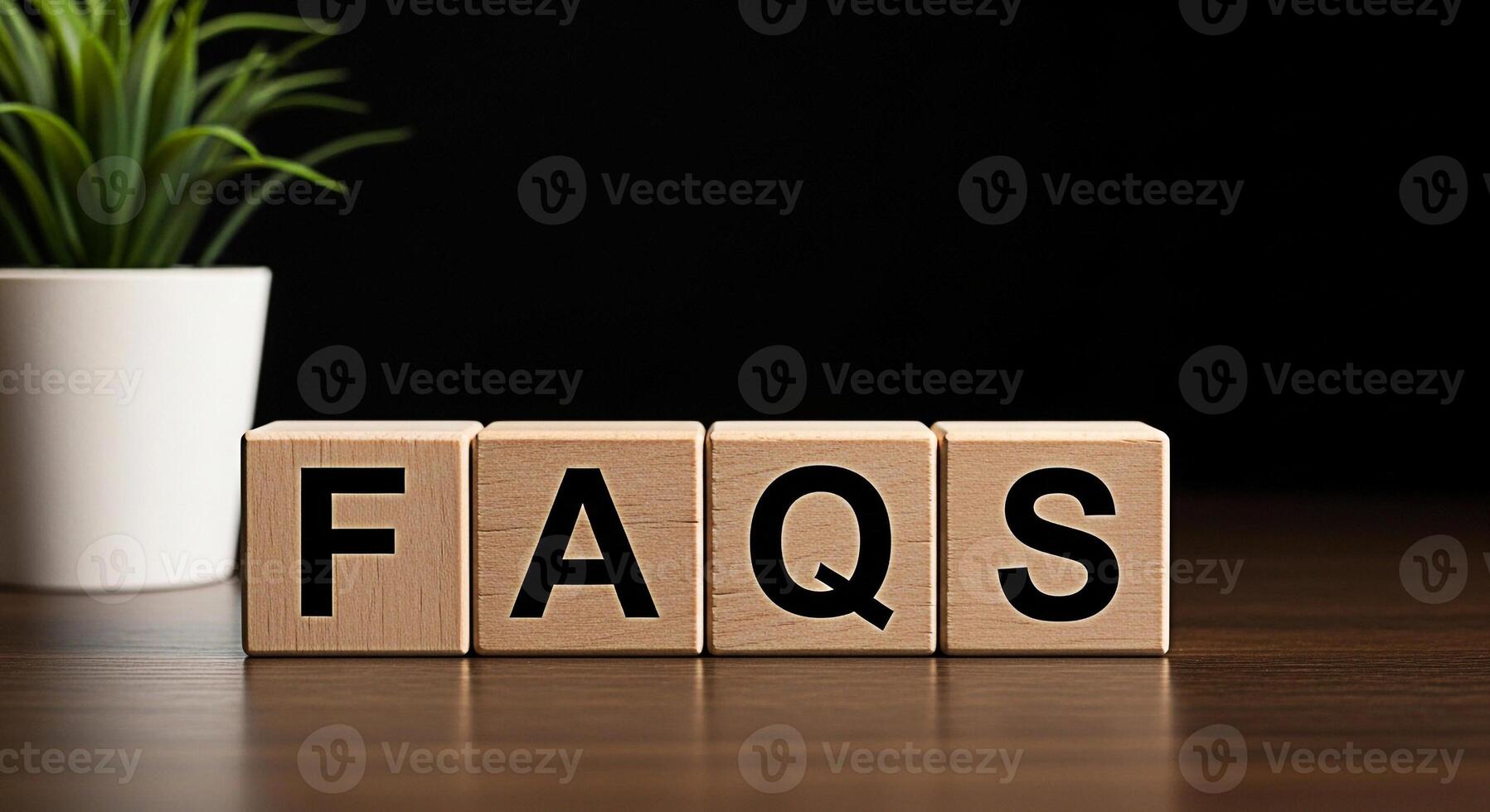 Wooden blocks spelling FAQs on a dark wooden table with a green plant in the background representing frequently asked questions and information creating a helpful and informative atmosphere photo