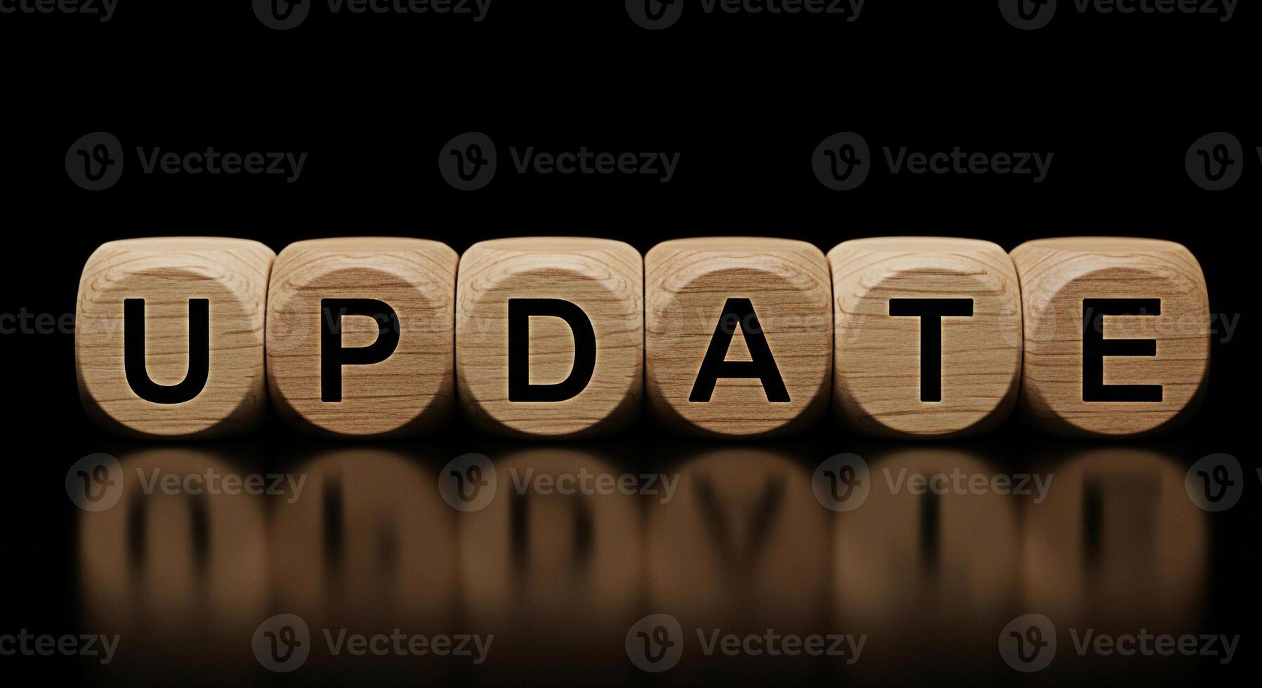 Wooden blocks spelling UPDATE on a reflective surface against a dark background symbolizing software updates information updates and the importance of staying current with the latest information and t photo