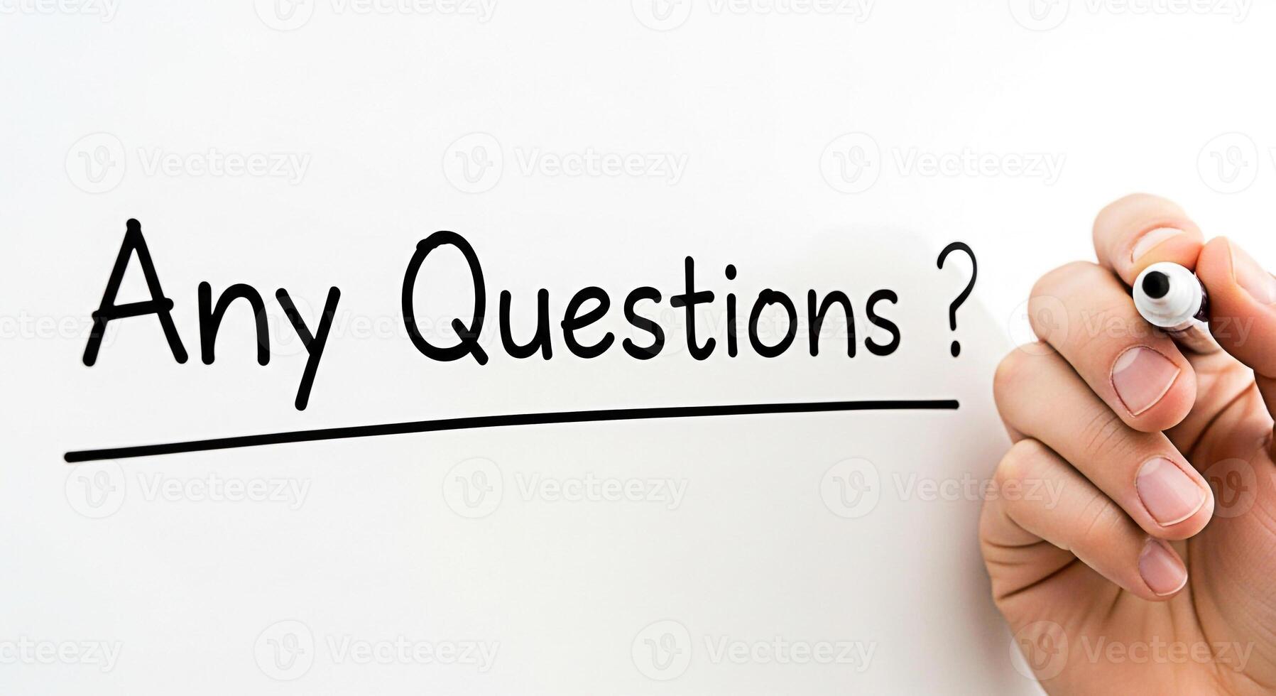 Hand holding a marker near a whiteboard with the text Any Questions in a bright clean environment representing an interactive and engaging atmosphere for learning and discussion photo