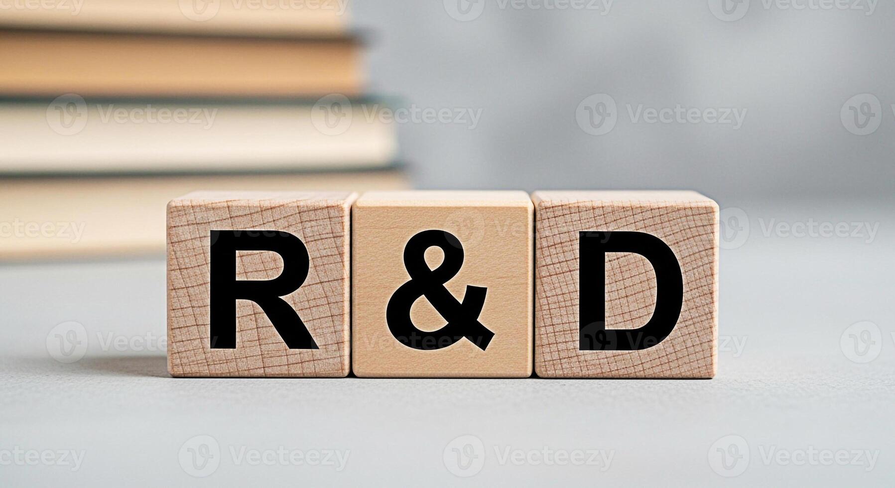 Wooden blocks spelling RD on a gray surface with blurred books in the background representing research and development innovation and the pursuit of knowledge in a neutral environment photo