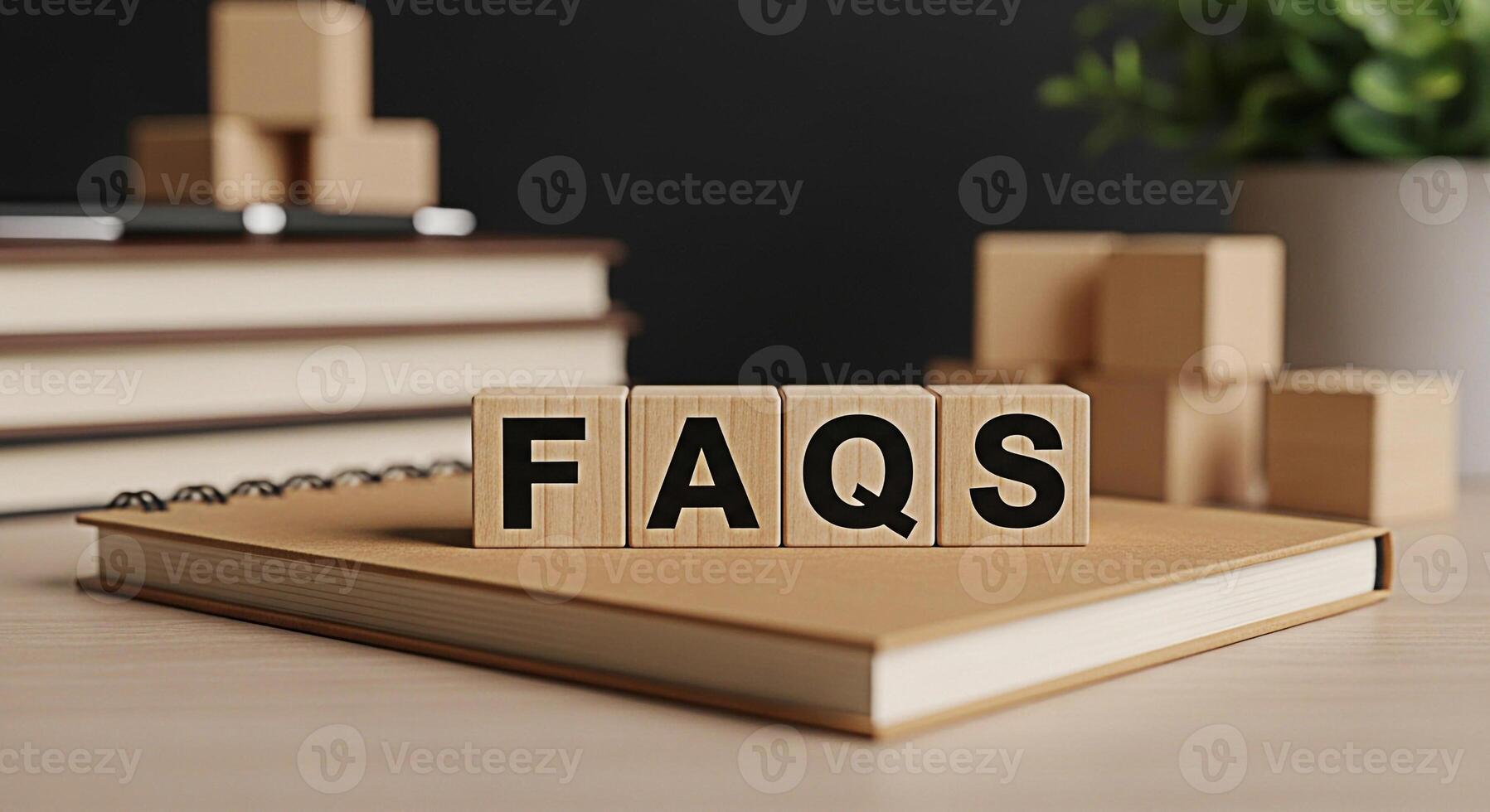 Wooden blocks spelling FAQs resting on a notebook in a bright office setting symbolizing information access and customer support for frequently asked questions and problemsolving assistance photo