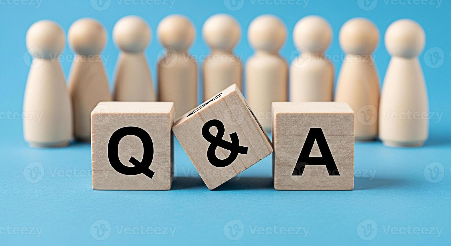 Wooden figures standing behind wooden blocks displaying Q A on a blue background representing a question and answer session fostering a collaborative and informative environment promoting knowledge sh photo