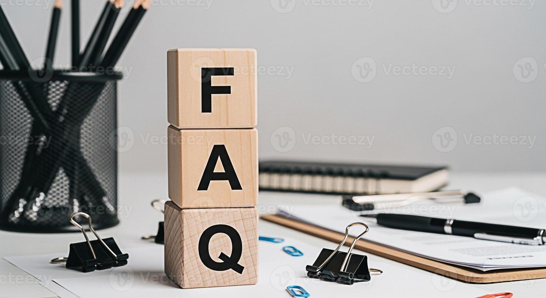 Wooden blocks displaying FAQ on a bright desk with stationery symbolizing accessible information and customer support in a professional and organized environment promoting clarity and assistance photo