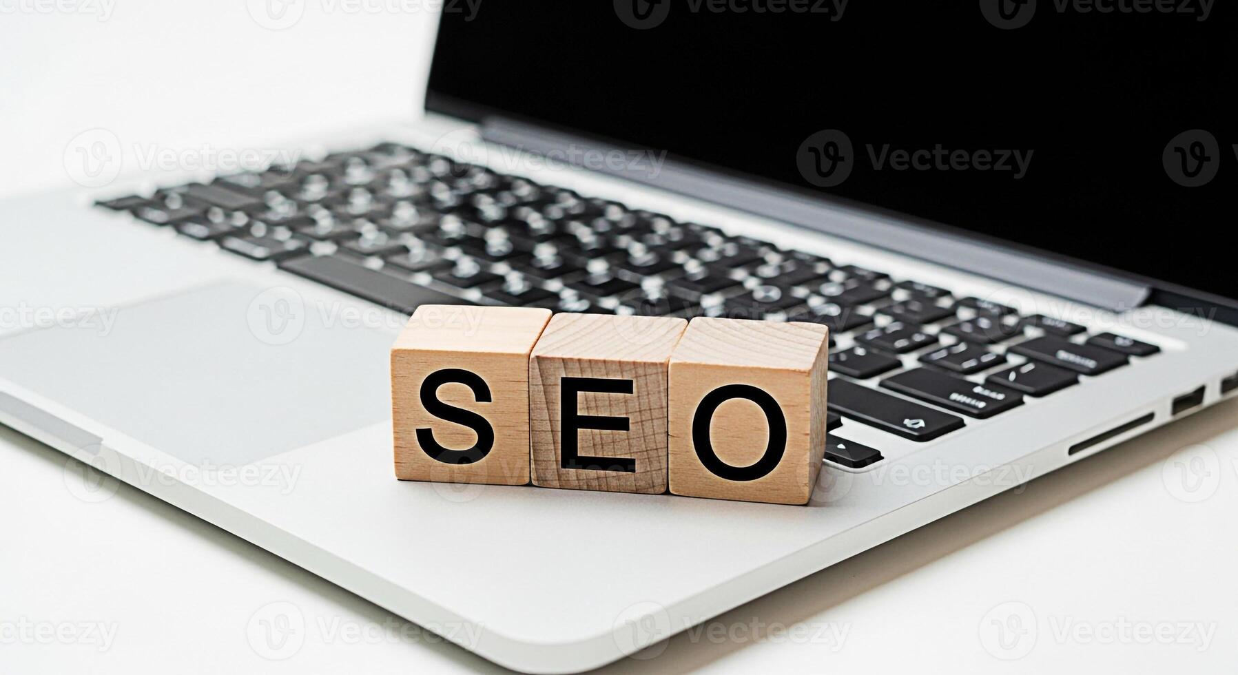 Wooden blocks spelling SEO resting on a laptop keyboard in a bright minimalist office setting representing search engine optimization and digital marketing strategies for online business success photo
