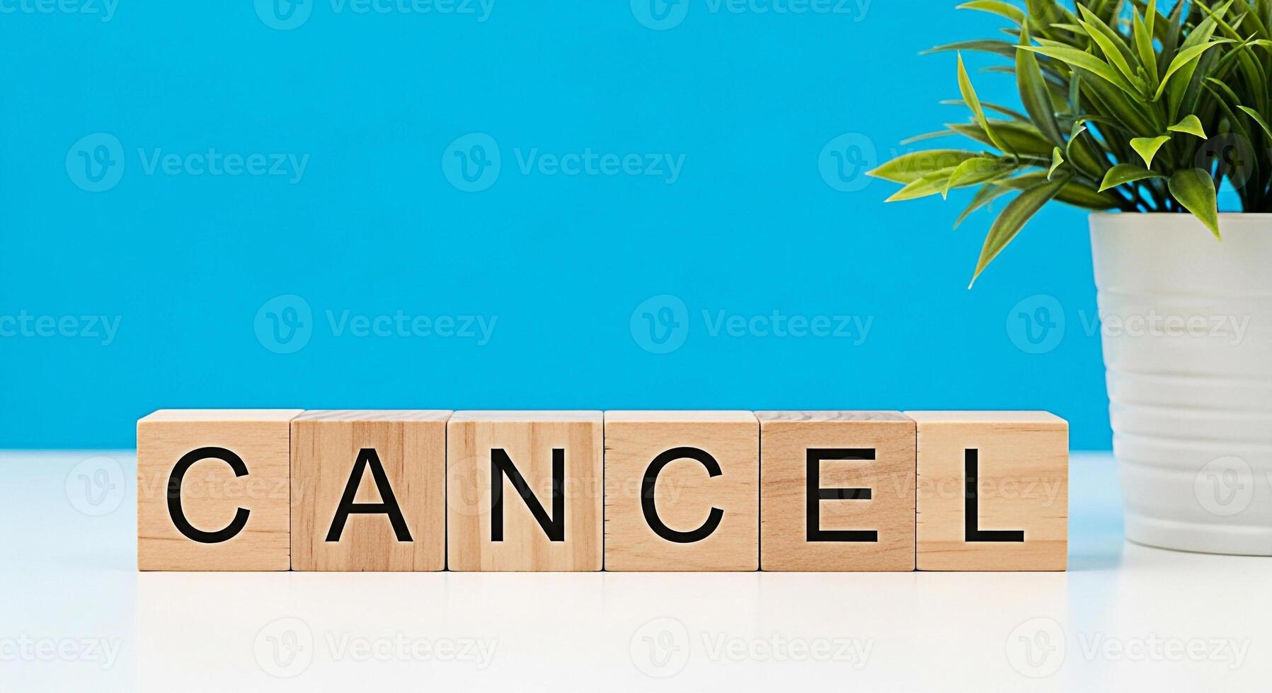Wooden blocks spelling CANCEL on a white table against a vibrant blue background conveying a message of termination cancellation or ending with a sense of finality and resolution photo