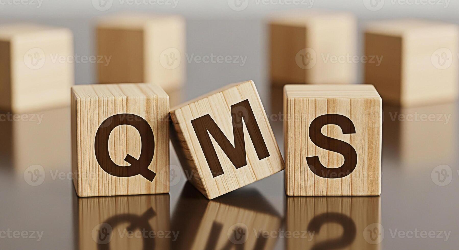 Wooden blocks displaying QMS on a reflective surface symbolizing quality management system implementation and continuous improvement in a corporate environment fostering trust and reliability photo