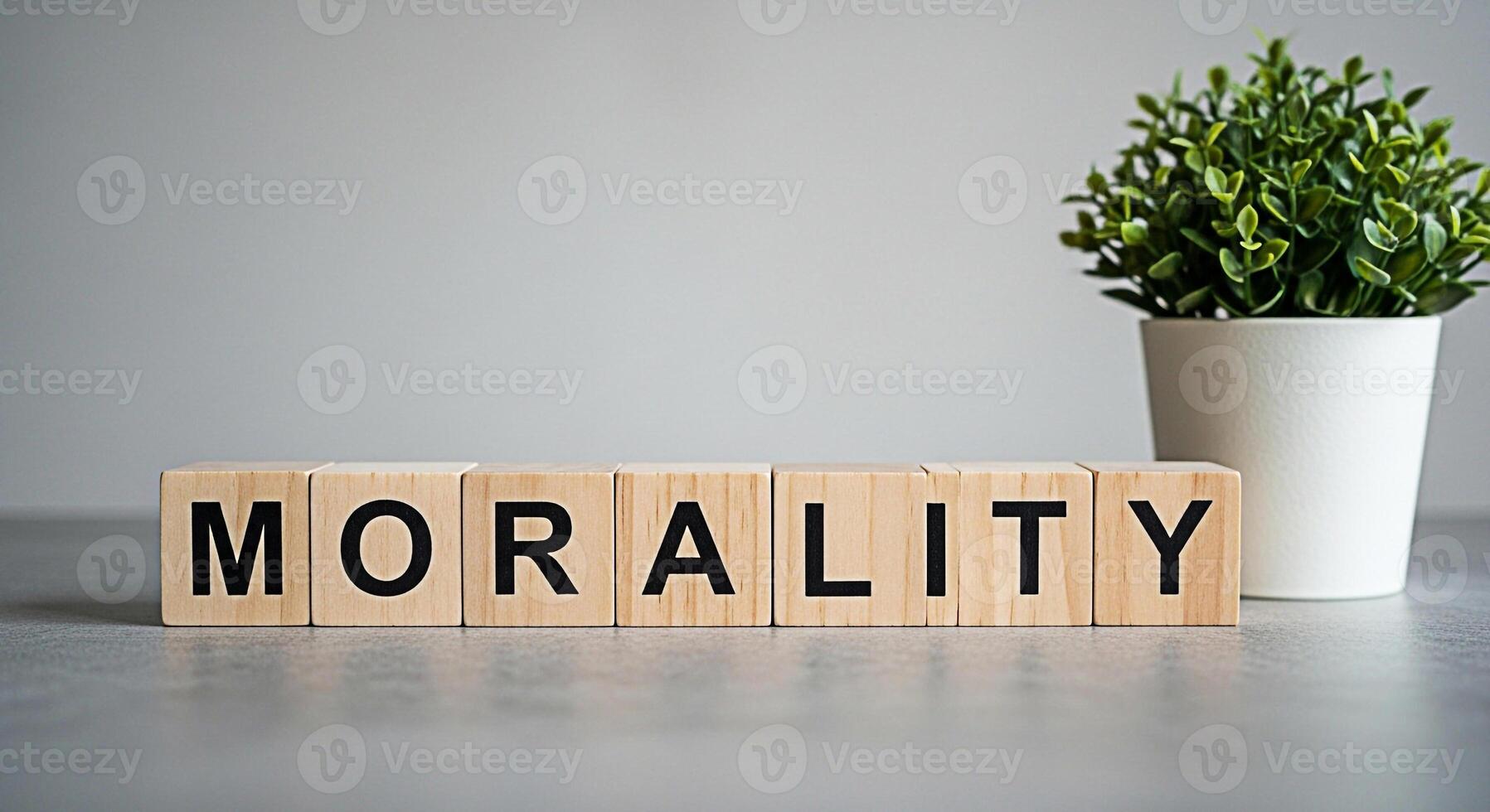 Wooden blocks spelling Morality displayed on a neutral surface next to a potted plant symbolizing ethical principles and a commitment to integrity in a clean and minimalist setting promoting trust and photo