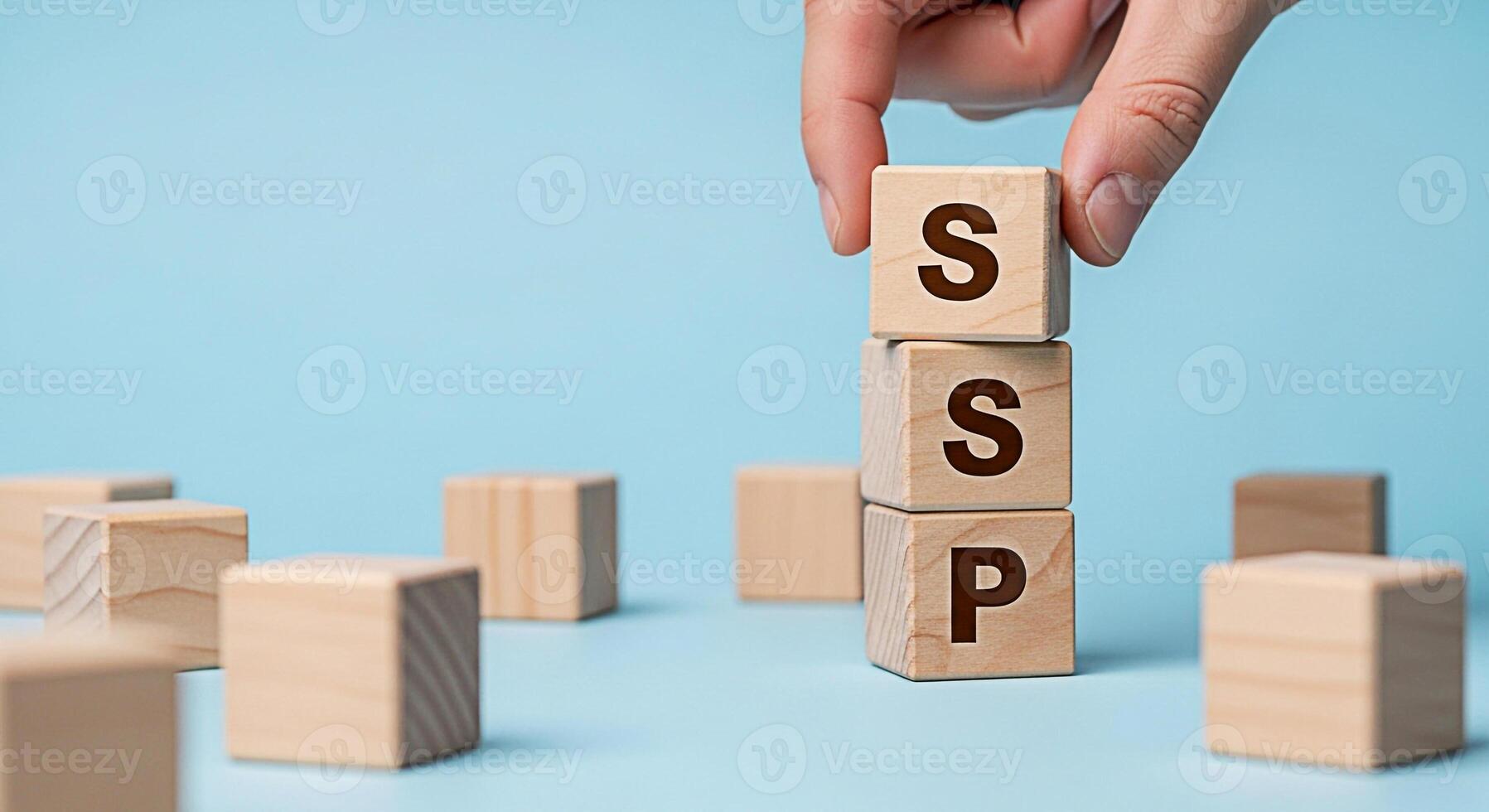 Hand arranging wooden blocks with SSP letters on a blue background symbolizing a Supply Side Platform for digital advertising conveying concepts of technology automation and programmatic advertising s photo