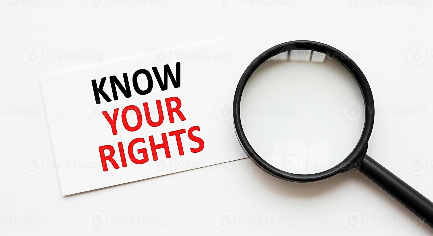 Magnifying glass focusing on a card with the message Know Your Rights on a white surface emphasizing awareness and legal empowerment in a minimalist and informative setting photo