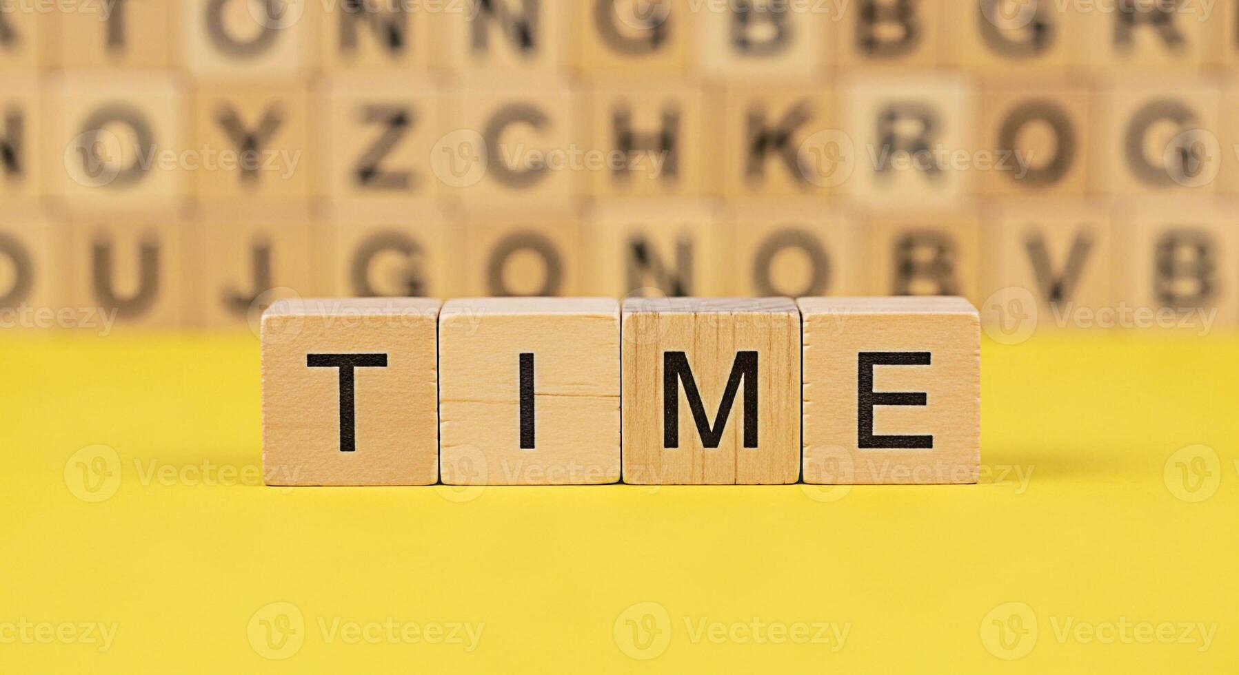Wooden blocks spelling TIME on a bright yellow surface representing the concept of time management deadlines and the importance of scheduling in a fastpaced world conveying a sense of urgency photo