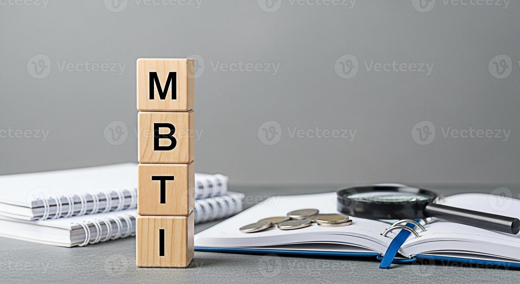 Wooden blocks spelling MBTI stacked on a desk with notebooks and a magnifying glass symbolizing personality assessment and career guidance in a professional and analytical environment photo