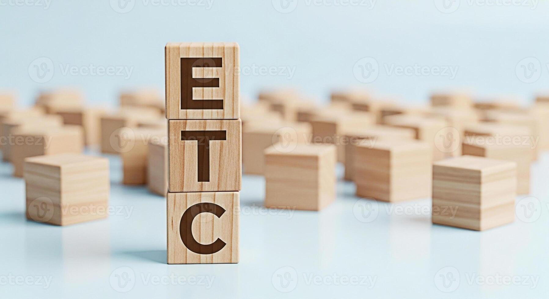 Stacked wooden blocks spelling ETC in a bright studio setting representing continuation and the concept of et cetera with a minimalist and clean aesthetic for business and educational purposes photo
