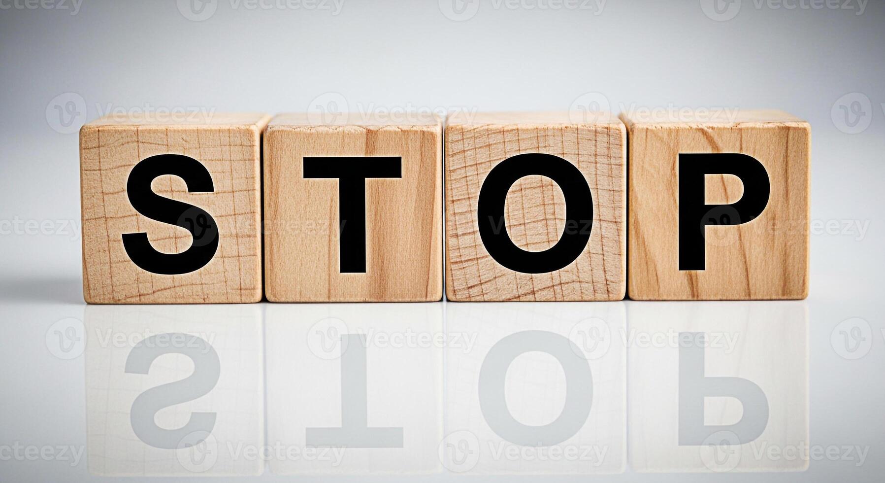 Wooden blocks spelling STOP on a reflective surface conveying a message of caution and prevention ideal for safety campaigns and awareness initiatives in a clean minimalist setting photo