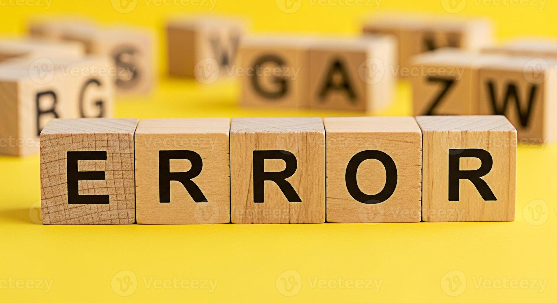 Wooden blocks spelling ERROR on a bright yellow surface surrounded by other letter blocks symbolizing a system failure a problem or a mistake in a playful and educational environment photo