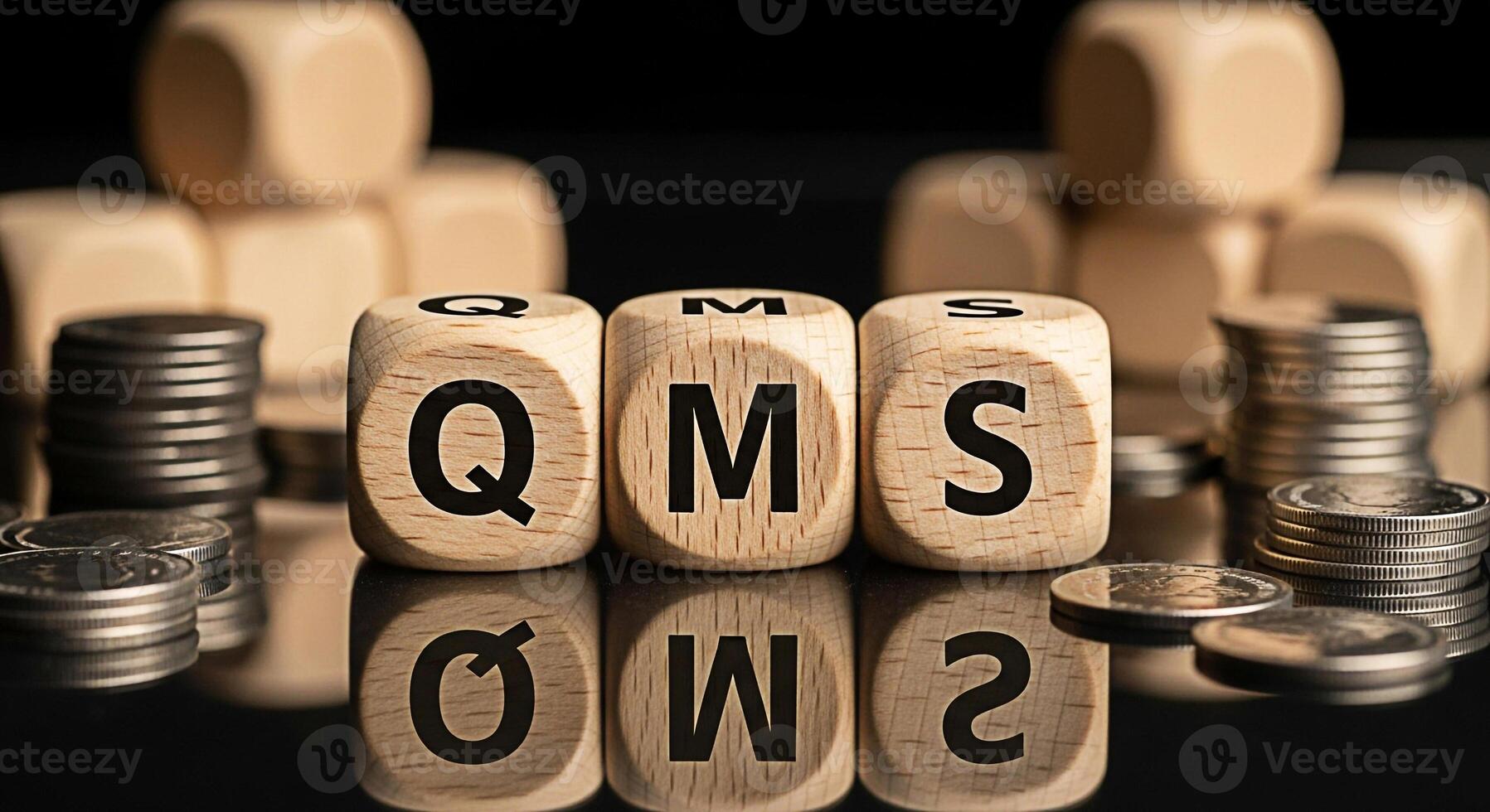 Wooden cubes displaying QMS abbreviation surrounded by stacks of coins on a reflective surface representing Quality Management System implementation and its financial impact on business success and pr photo