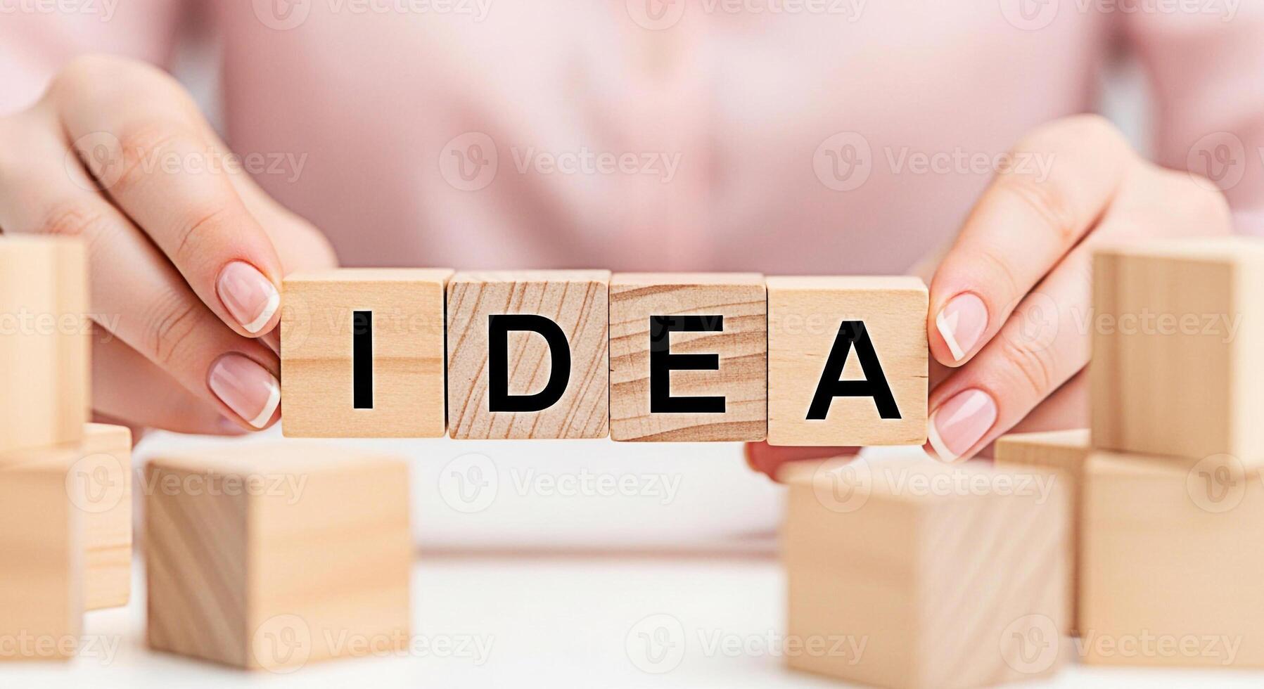Womans hands arranging wooden blocks spelling IDEA on a white surface symbolizing creativity and innovation fostering a bright and imaginative atmosphere for brainstorming and problemsolving photo
