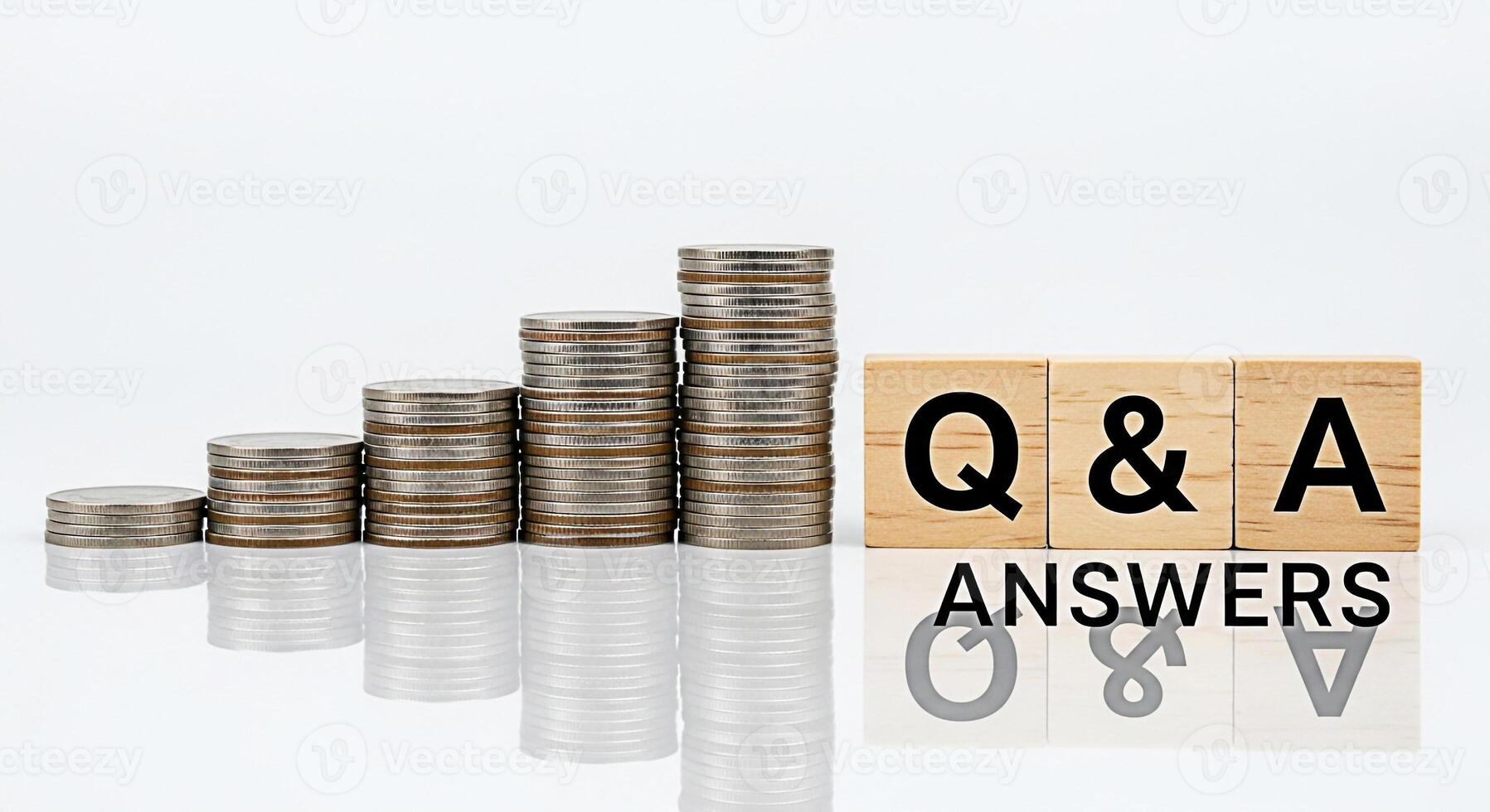 Stacks of coins increasing in height next to wooden blocks spelling Q A on a reflective white surface symbolizing financial growth investment strategies and finding answers to business questions photo