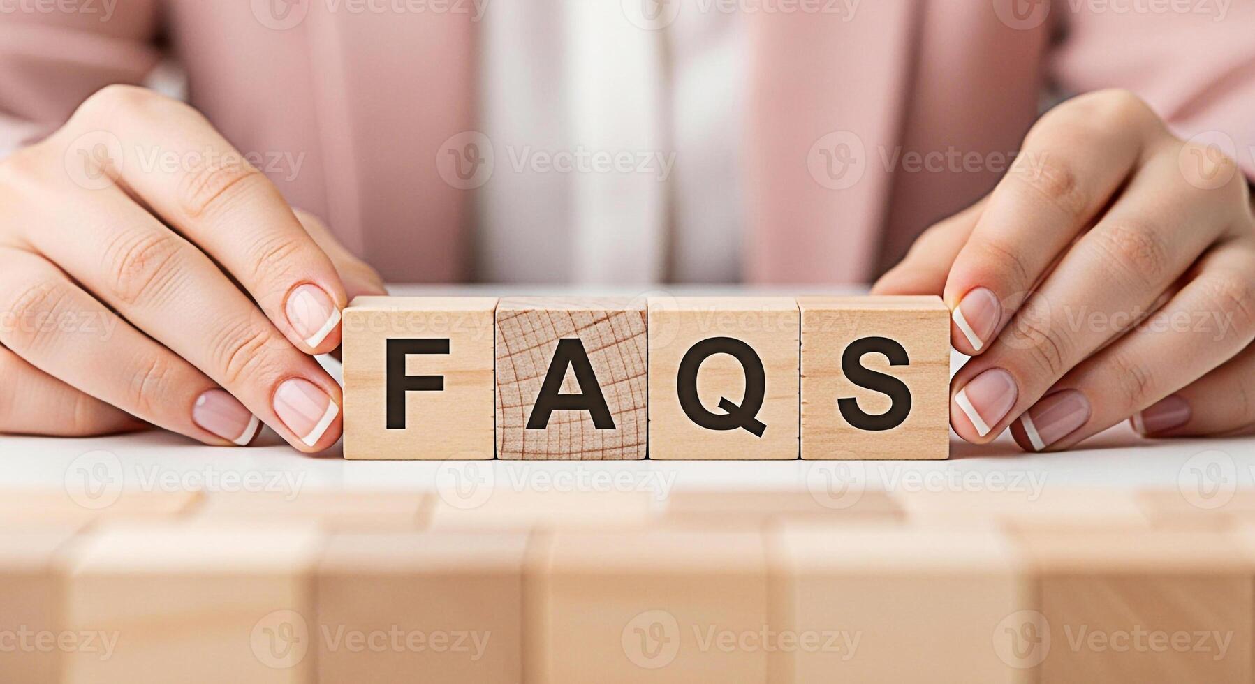 Female hands arranging wooden blocks spelling FAQs on a white surface symbolizing accessible information and customer support in a clear and concise manner promoting trust and transparency photo