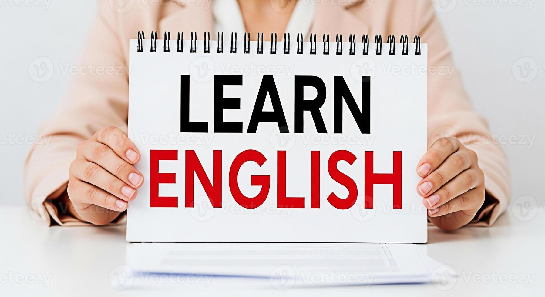 Person holding a notepad with the words Learn English in a bright studio setting promoting education and language acquisition with a focus on clarity and accessibility for language learners photo