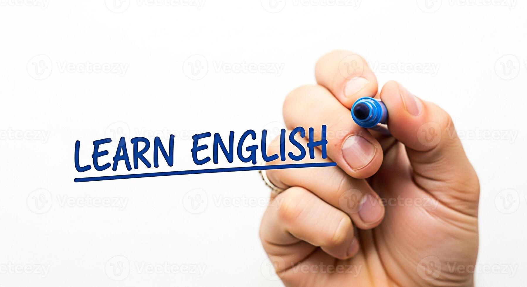 Closeup of a hand writing Learn English on a whiteboard with a blue marker symbolizing education and the importance of language skills in a modern globalized world fostering a sense of opportunity and photo