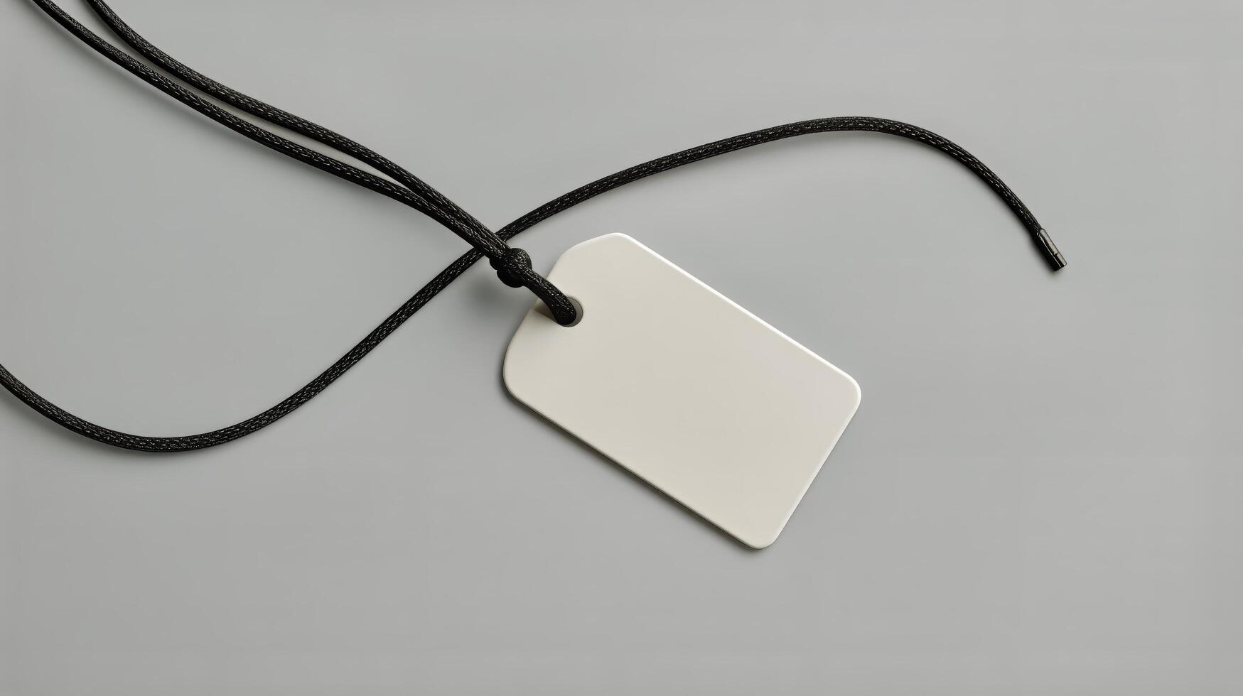 White Tag on Black Cord Against Gray Background Creating a Minimalist Design photo