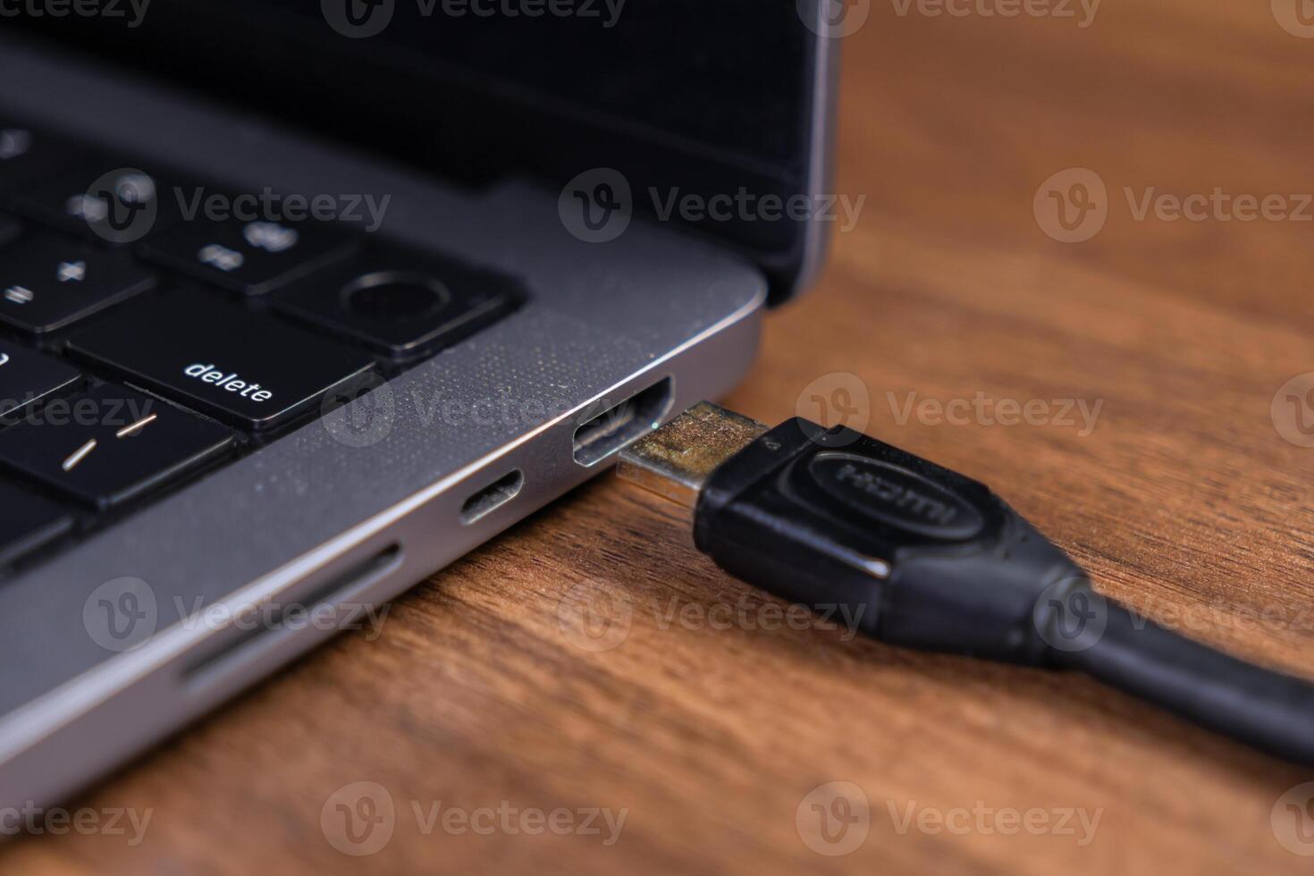 Close-up view of an HDMI cable connected to a laptop's port, highlighting seamless digital connectivity and efficient data transfer for display integration photo