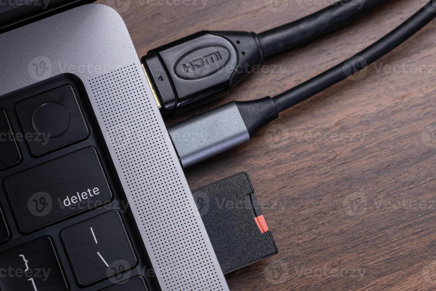 Sleek laptop featuring HDMI cable and memory card reader connections, representing essential digital device connectivity and efficient data transfer solutions photo