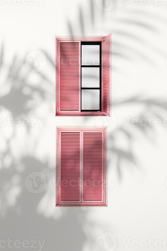 Retro Windows with pink closed Shutters Jalousie on light pink background with palm tree shadow, Window frame as pattern on outdoor wall building. Minimal design abstract. Summer, travel concept photo