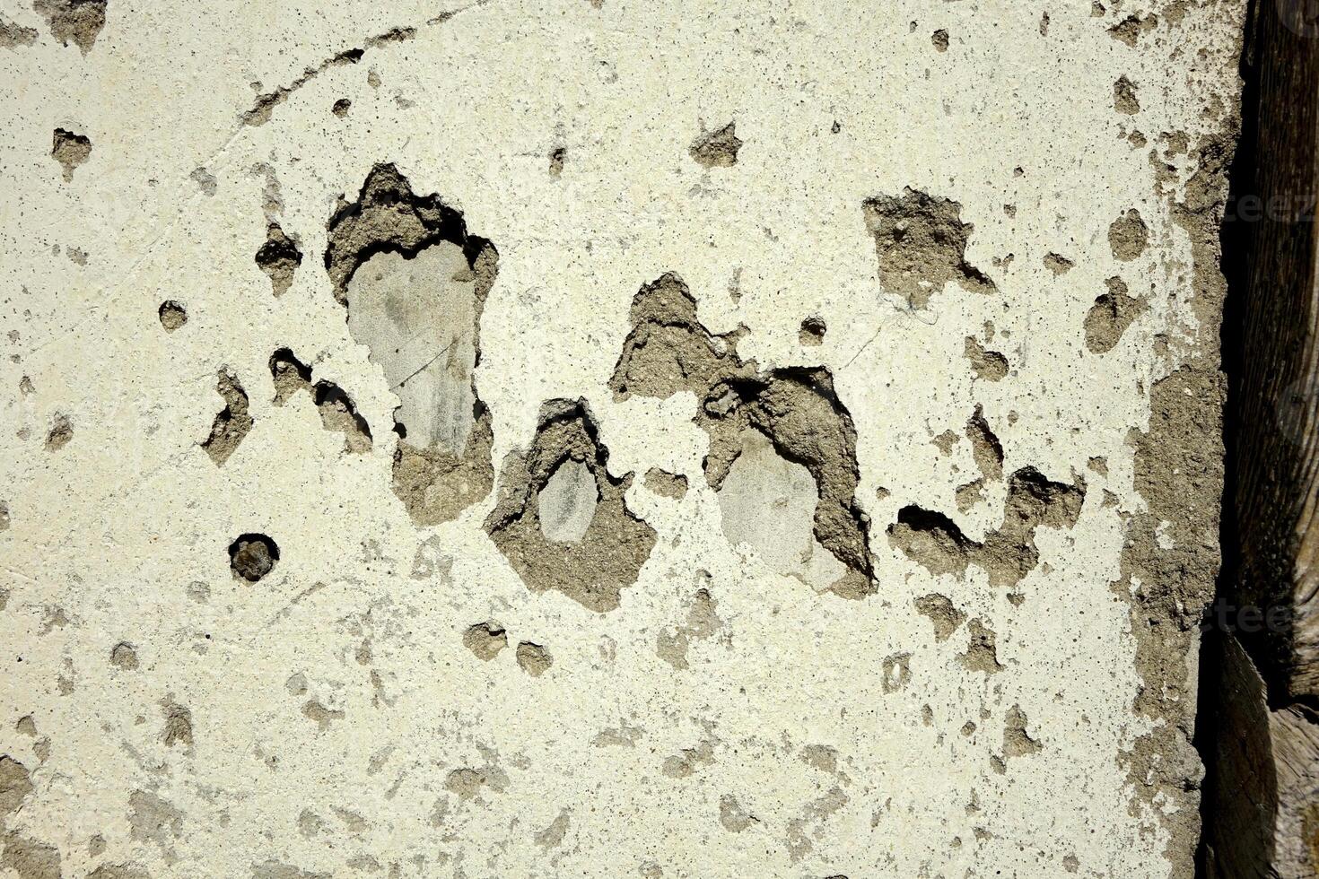 Detailed View of a Textured Plaster Wall With Weathered Patches and Exposed Layers in Natural Light photo