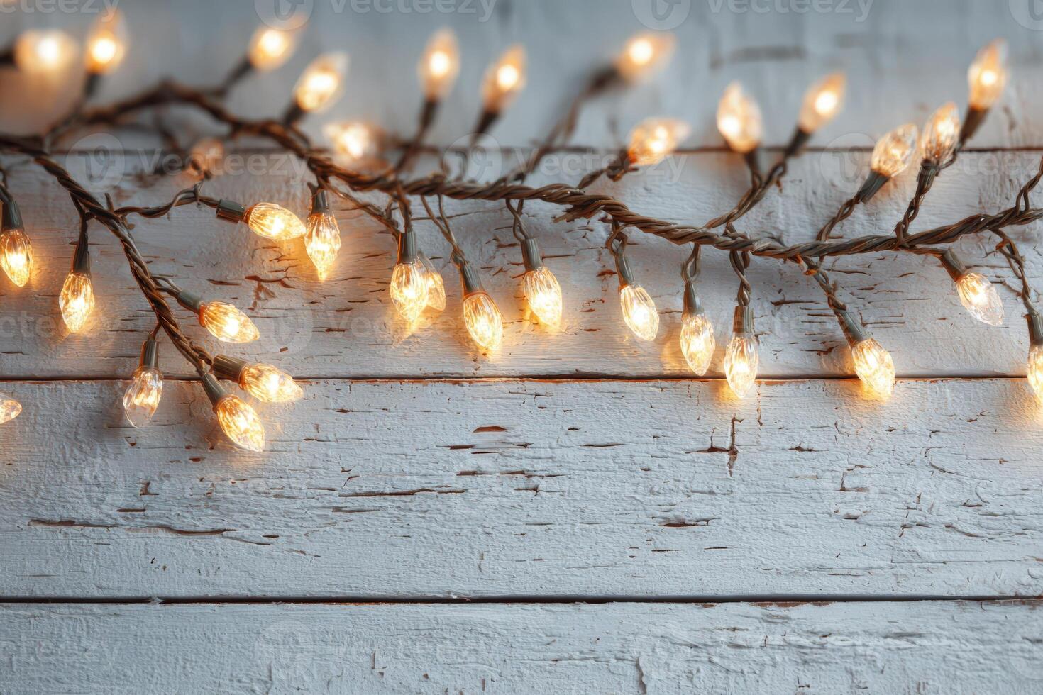 String of warm white fairy lights draped over rustic wooden surface, creating a cozy and inviting atmosphere for festive celebrations or home decor photo