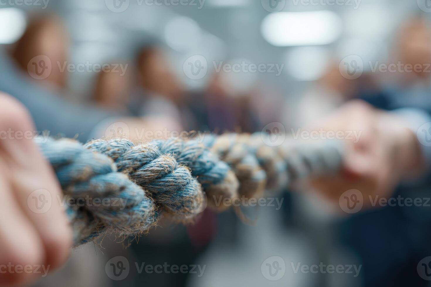 Group of diverse individuals engaged in a tug of war competition, showcasing teamwork and collaboration, with blurred background emphasizing the intensity of the moment photo