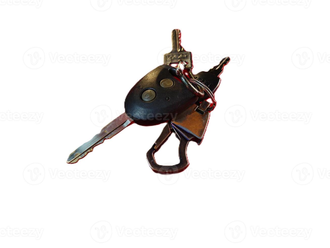 A close-up view of a keychain with a car key remote and several metallic keys isolated on a white background photo