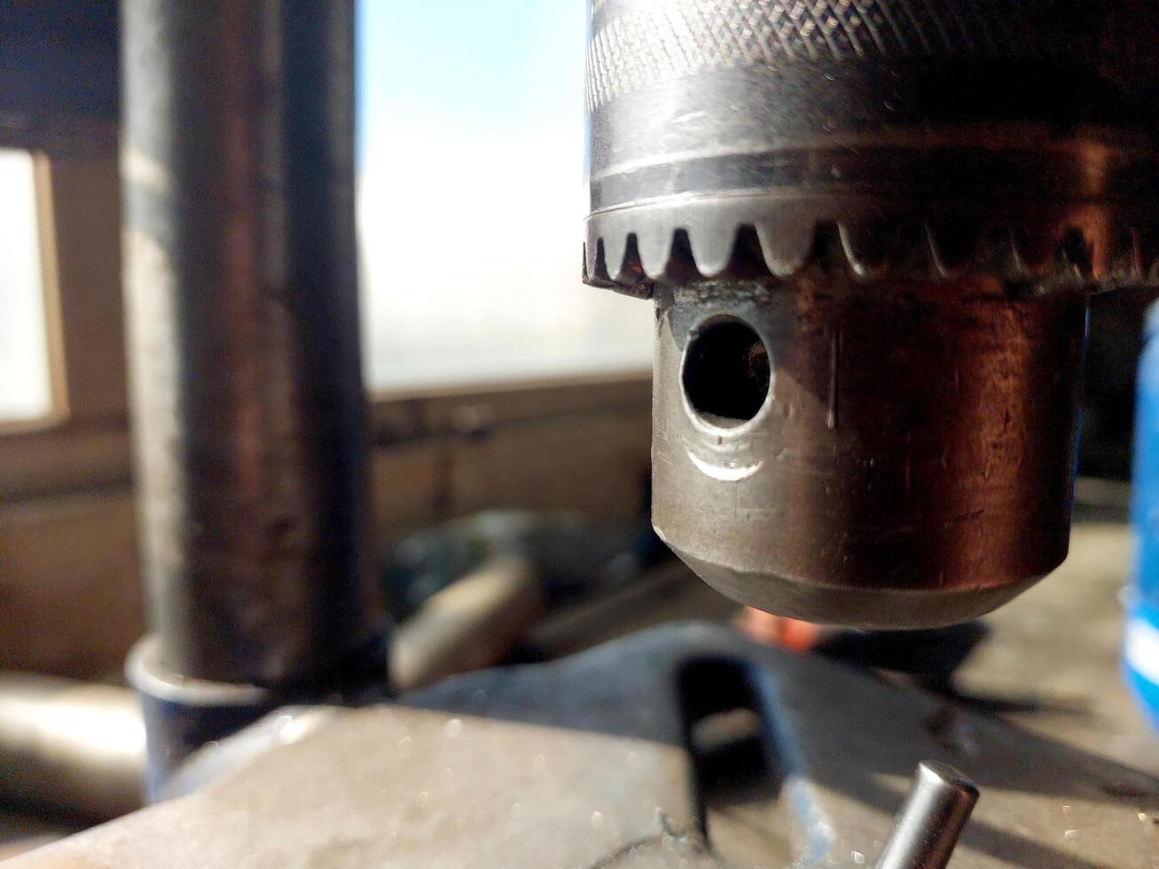 Close View of Drilling Machine Chuck During Metalworking Process in Workshop Setting photo