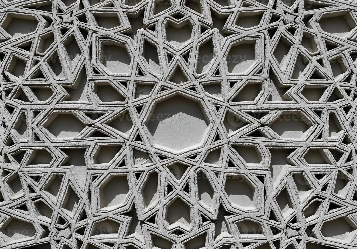 Intricate three-dimensional Islamic geometric pattern on a stone facade, showcasing detailed ornamentation and traditional Moorish design with strong shadows photo