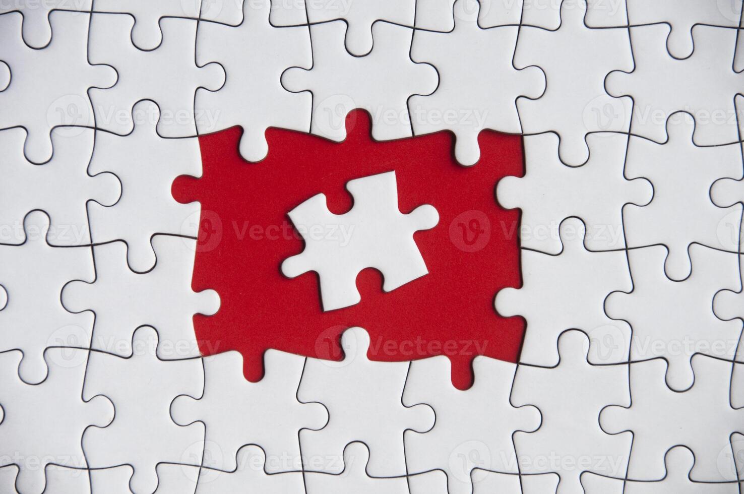 Top view of blank spaces on jigsaw puzzle with on piece placed in the middle. Customizable space for tex photo