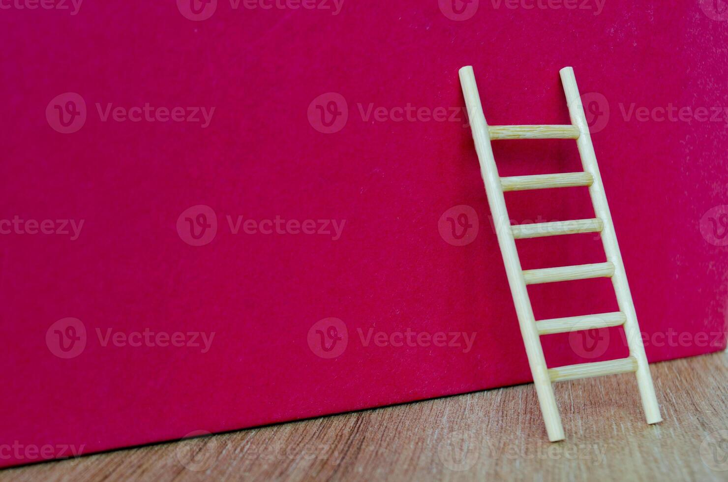 Side view of small ladder on dark red cover background with customizable space for text. photo