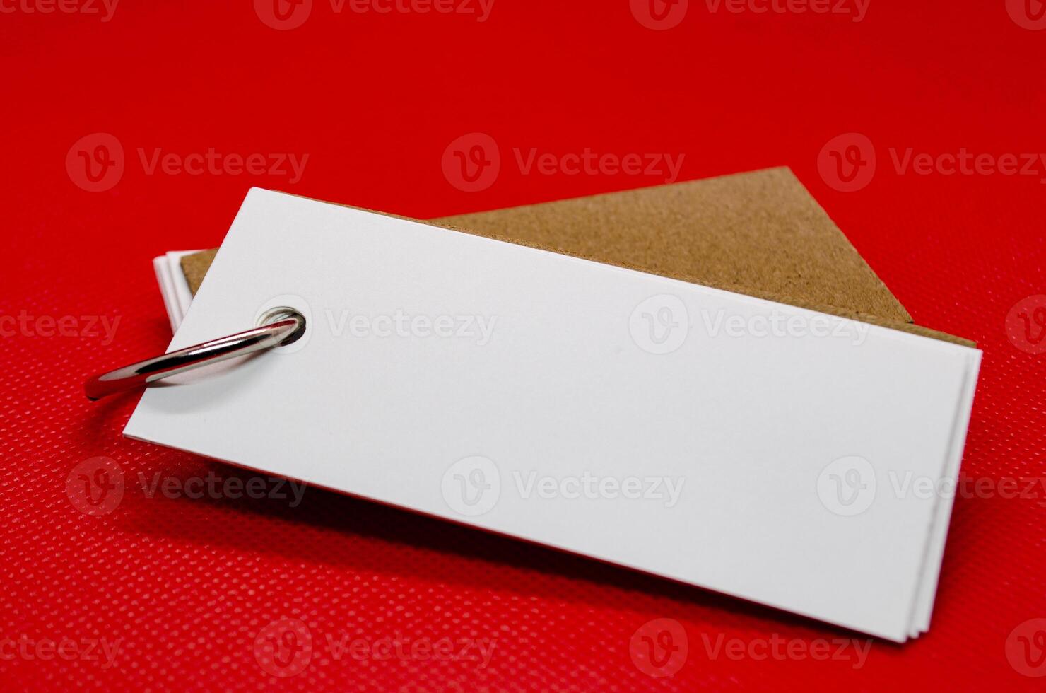 Close up of white banner shape notepad with customizable space for text on red cover background. Copy space concept. photo