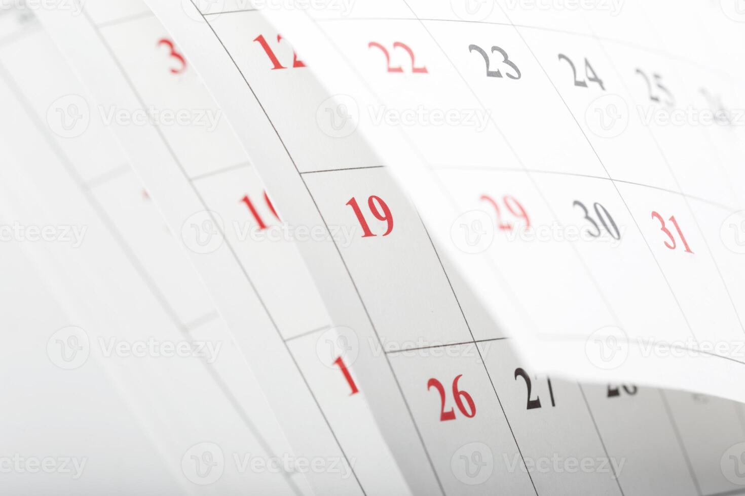 Calendars displaying dates with some numbers highlighted in red for important events photo