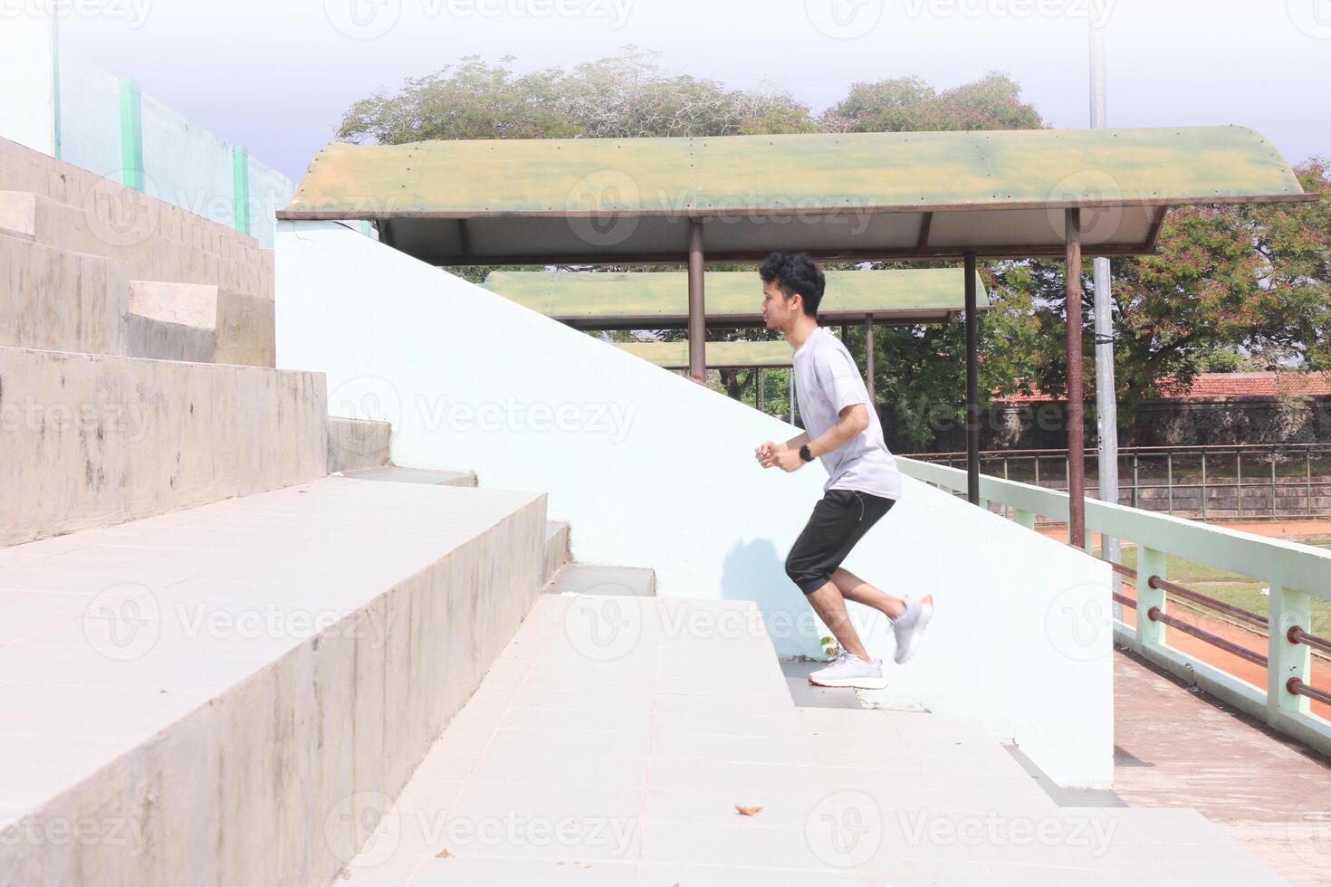 A man is running up a set of stairs. Concept of determination and physical exertion photo