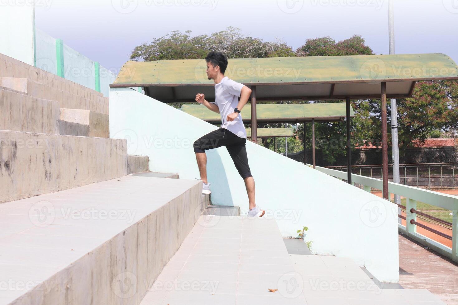 A man is running up a set of stairs. Concept of determination and physical exertion, photo