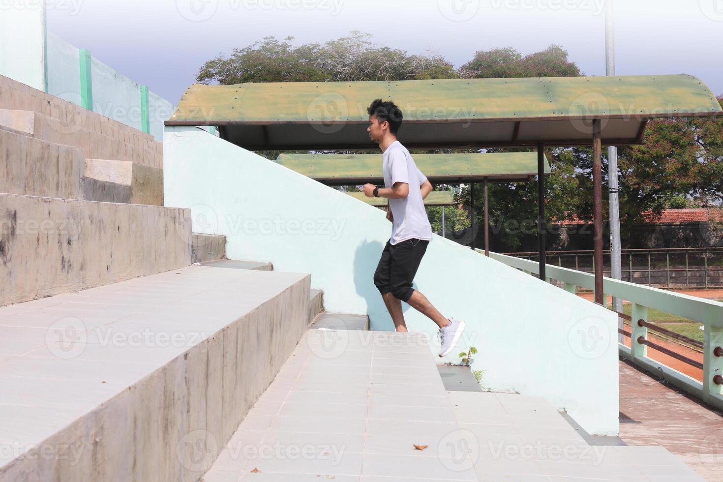 A man is running up a set of stairs. Concept of determination and physical exertion. photo