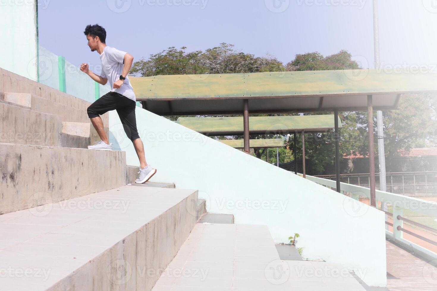 A man is running up a set of stairs. Concept of determination and physical, exertion. photo